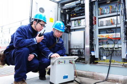 (国网重庆电力公司检修分公司员工正在认真对变电站设备进行调试